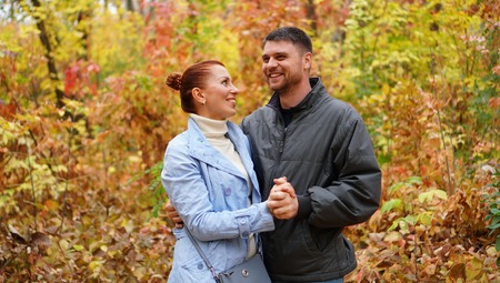 Love, relationship, family and people concept of couple hugging in autumn parkの写真素材