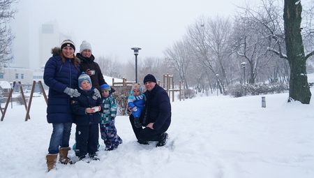 Two family having snapshot on holiday In winter parkの写真素材