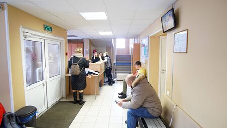 Moscow,Russia - February 09, 2019.Parents reading and talking while waiting for their kids training in the gym.のeditorial素材