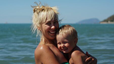Mother and her little son posing in the water at sunset. Vacation, travel conceptの写真素材