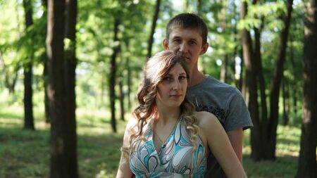 Portrait of a family outdoors. young parents in a summer park.の写真素材