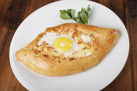 Khachapuri - traditional georgian pie with potatoes and cheese on a white plate.の写真素材