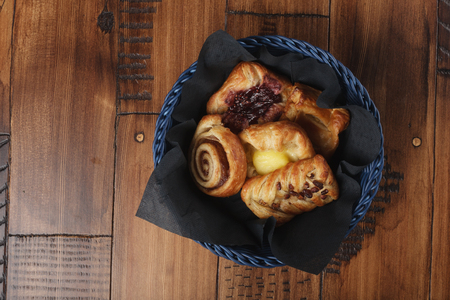 Sweet homemade buns in a blue basket.の写真素材