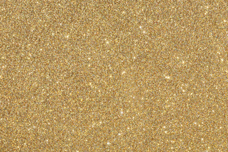 Golden (yellow) glitter background. Sparkle texture. Abstract twinkle background for New Years or Christmas holidayの写真素材