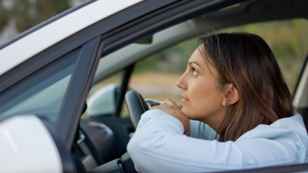 View through the open window of an attractive woman waiting patiently in her carの写真素材