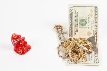 Conceptual image of a collection of gold jewellery, a red rose love ornament and moneyの写真素材