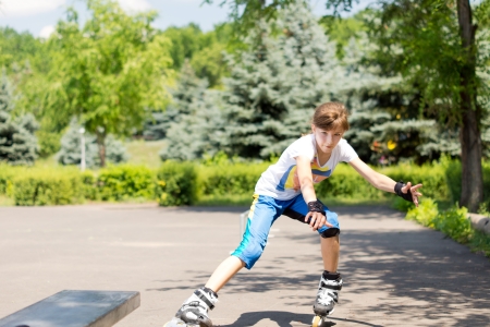Young girl out roller skating approaching the camera at speed in her  blades with her arms outstretched for balanceの写真素材