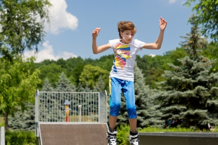 Beautiful teenage girl roller skating in parkの写真素材