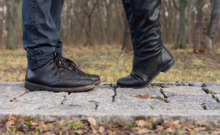 Suggestive image of a girl reaching up for a kiss showing the feet of the young couple close together facing each other with her standing on tiptoe to reach his lips in a romantic interludeの写真素材