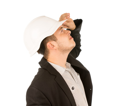 Close up Young White Engineer in White Helmet Looking Up. Isolated on White Background.の写真素材