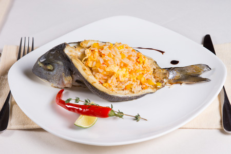 Rice Stuffed Fish Dish on Plate Place Setting in Restaurant