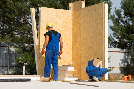 Two Male Construction Workers Busy in Building Real Estate Houseの写真素材
