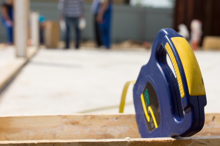 Blue plastic retractable builders tape measure on a building site with copyspace for your text