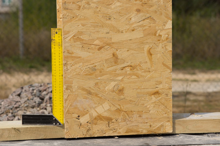 Right angle or set square on a building site being used to ensure that a wooden wall panel has been...