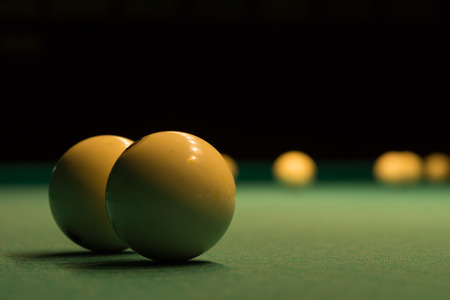 Close up White Shiny Billiard Balls on Green Pool Table on Black Background.の写真素材