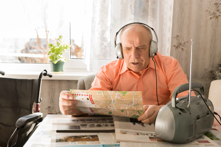 Close up Updated Old Bald Man, Sitting at the Table in Living Room, Listening Music From Radio with...