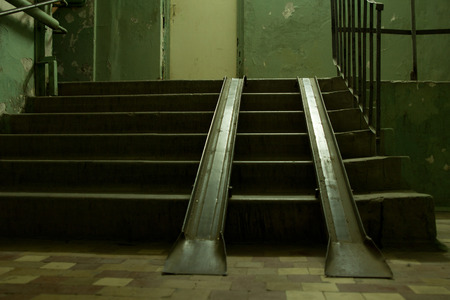 Two metal ramps overlaying a flight of concrete steps to allow for loading and access for vehicles or wheelchairsの写真素材