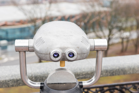 Viewing binoculars for tourists at an outlook point mounted in front of a silver rail overlooking the viewの写真素材