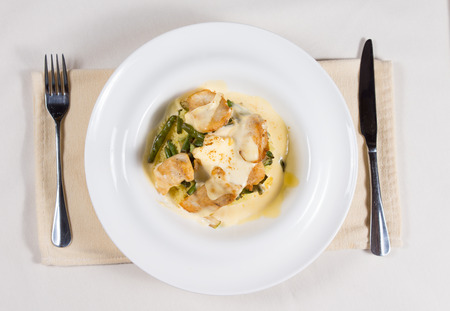 High Angle View of Creamy Prepared Dish Served in White Bowl at Simple Place Setting with Knife and Forkの写真素材