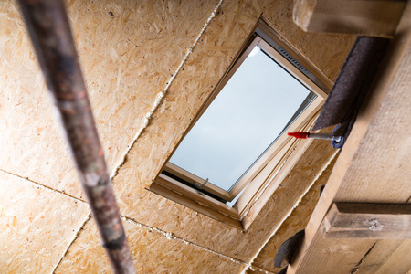 Low Angle View of Ceiling Sky Light in Unfishined Home with Exposed Particle Plywood Board and Fresh Caulking and Scaffoldingの写真素材