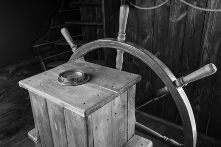 Detail of Antique Wooden Steering Helm with Wheel and Compass, Black and White Image of Historical Sailing Shipの写真素材