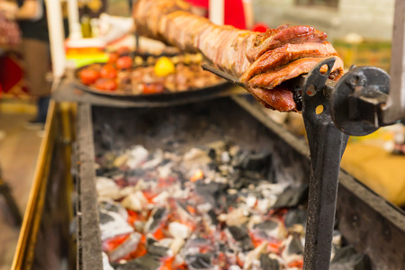 Close Up of Shawarma Meat Roasting on Spit Over Hot Coals at Food Cart Preparation Stationの写真素材