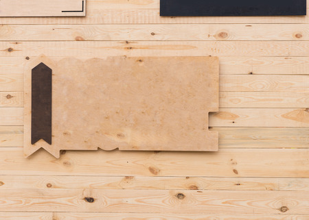 Blank rustic wooden sign with arrow and copy space pointing upwards hanging on a wooden wall in a full frame background viewの写真素材