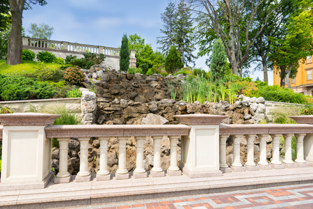 Landscape design with marble fence, many rocks and with background of different trees and plantsの写真素材