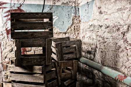 Wooden packing crates are arranged one on one in terrible basement in a Halloween horror conceptの写真素材