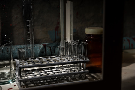 Frightening Halloween theme blood of stained laboratory with test tubes holder and other medicine devices insideの写真素材