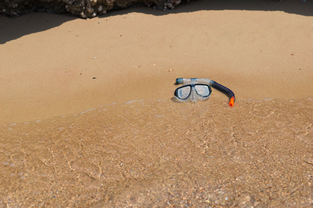 Underwater mask and tube lying in the sand on the beach on a sunny summer dayの写真素材