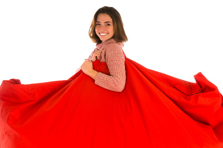 Smiling woman holding on her shoulder red rectangular shaped beanbag sofa chair for living room or other room isolated on white backgroundの写真素材