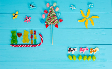 Funny picture of jelly candies in the shape of bears in love are sledging and trees on wooden...