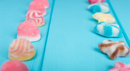 Close up of delicious jelly candies in the shape of stars and circles which are placed in the ranks...