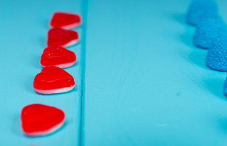 Close up of delicious jelly candies in the shape of a heart which are placed exactly in the ranks on wooden tableの写真素材