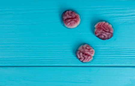 Tasty jelly candies in the shape of a brain on wooden turquoise tableの写真素材