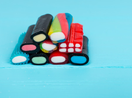 Colorful delicious chewy candies on wooden turquoise boardの写真素材