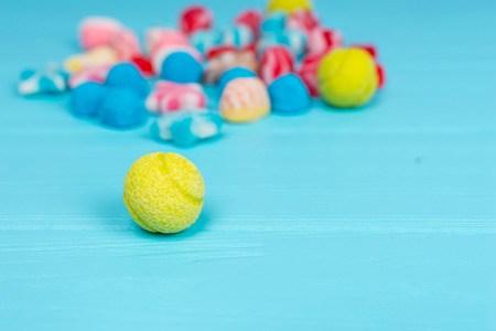 Tasty candy in the shape of tennis ball  on wooden table, bunch of tasty jelly candies on a backgroundの写真素材