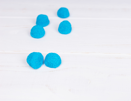 Blue tasty jelly candies on wooden white tableの写真素材
