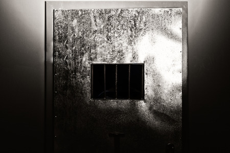 Iron prison door with a hole with bars