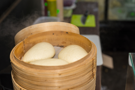 Chinese steamed bun in bamboo steamed at outdoor food festival. Food and beverages conceptの写真素材