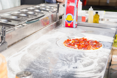 Raw pizza on the kitchen surface with flour. Food and beverages conceptの写真素材