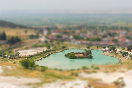 A turquoise blue lake below the travertine terraces at the hot springs, Pumakkale, Anatolia, Turkey a UNESCO World Heritage Site with tilt-shift focusの写真素材