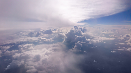 Scenic view of sun shining above cloud formations high in sky.