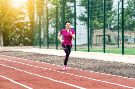 Young female runner sprinting for the finish during a workout and training session at an outdoor...