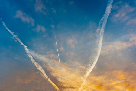 three tracks from an airplane in the sky move to the sunsetの写真素材