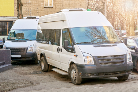 Two new white minibuses are parkedの写真素材