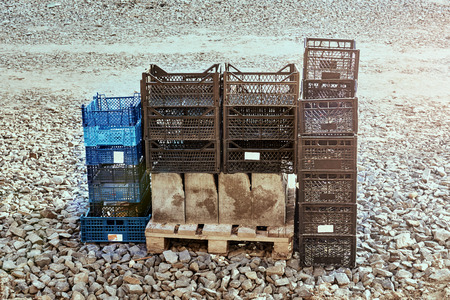 Plastic boxes for vegetables in a pile stand on the ground and a palletの写真素材