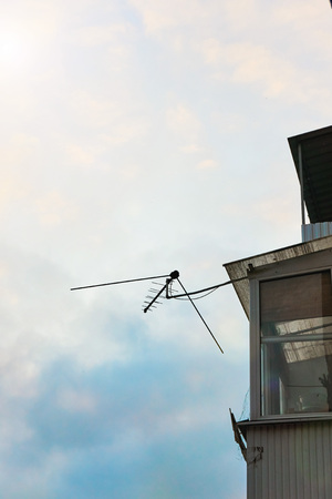 An analogue old antenna for the TV hangs on the ramshackle on the balconyの写真素材