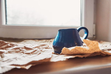 Blue clay milk jug made by hand in a pottery workshopの写真素材